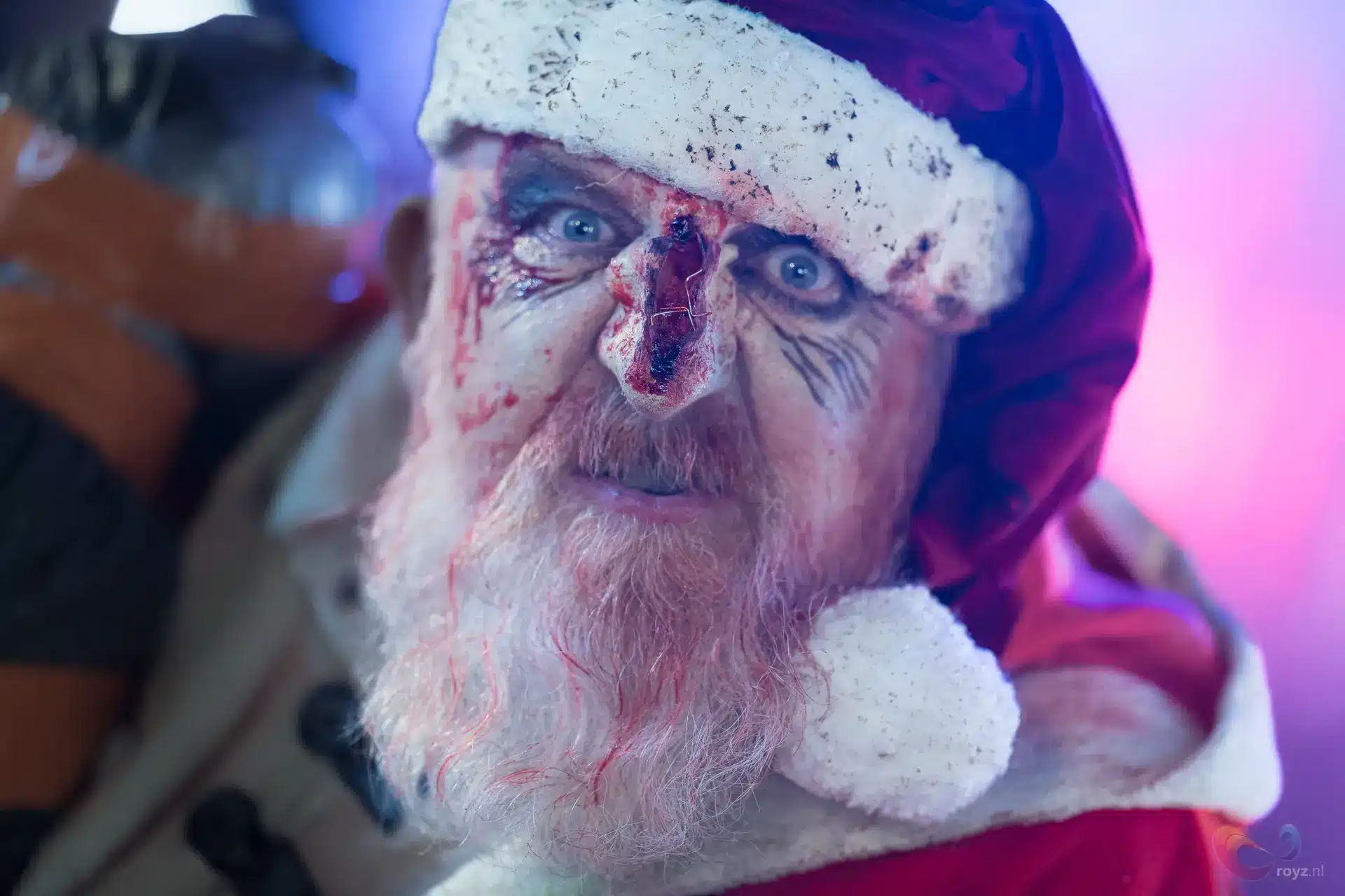 Neon Santa met bloedvlekken in kerstmanoutfit en filmische horror-sfeer.