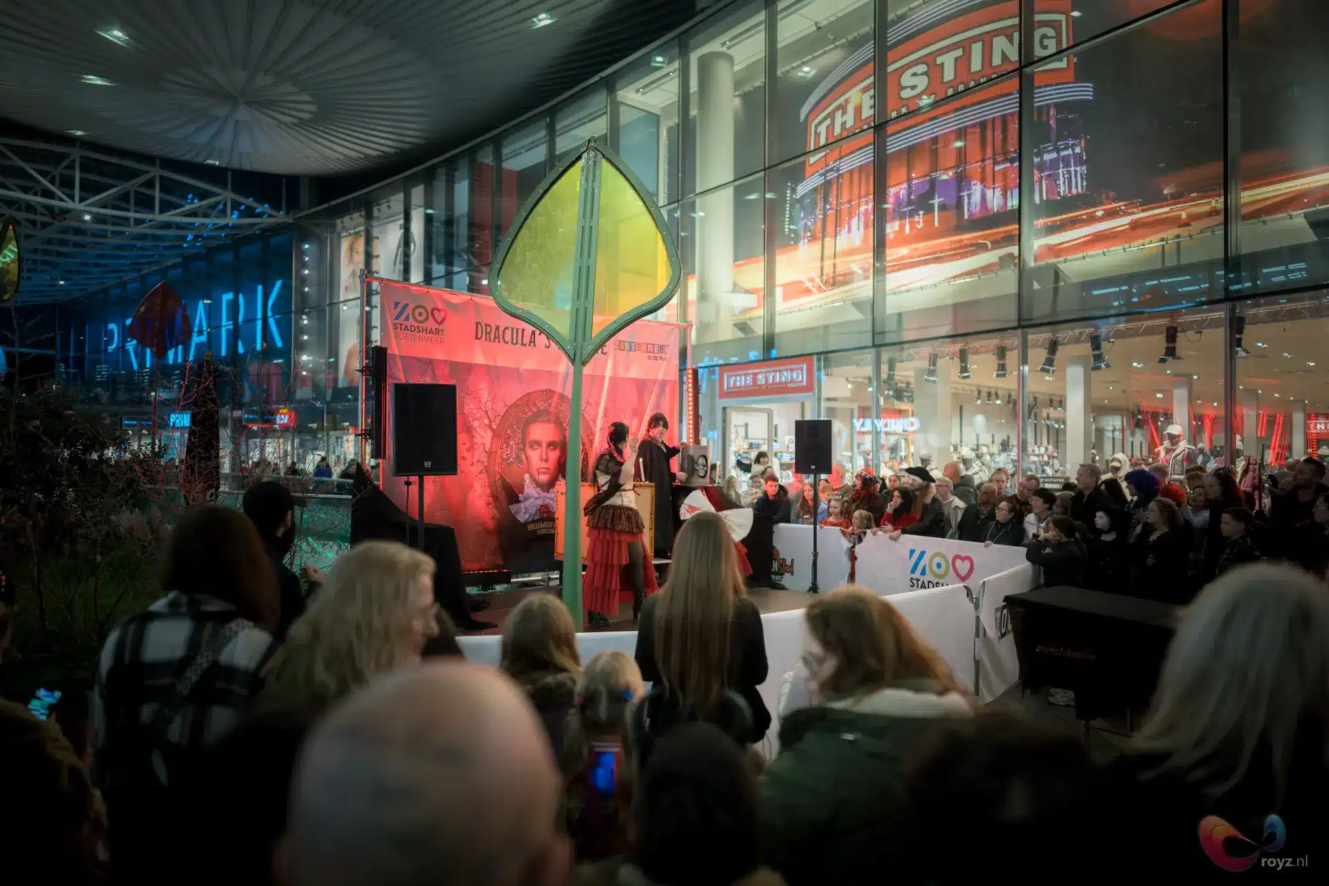 Dracula-show in Zoetermeer atrium met twee artiesten en bladsculptuur, publiek geniet van live-entertainment.