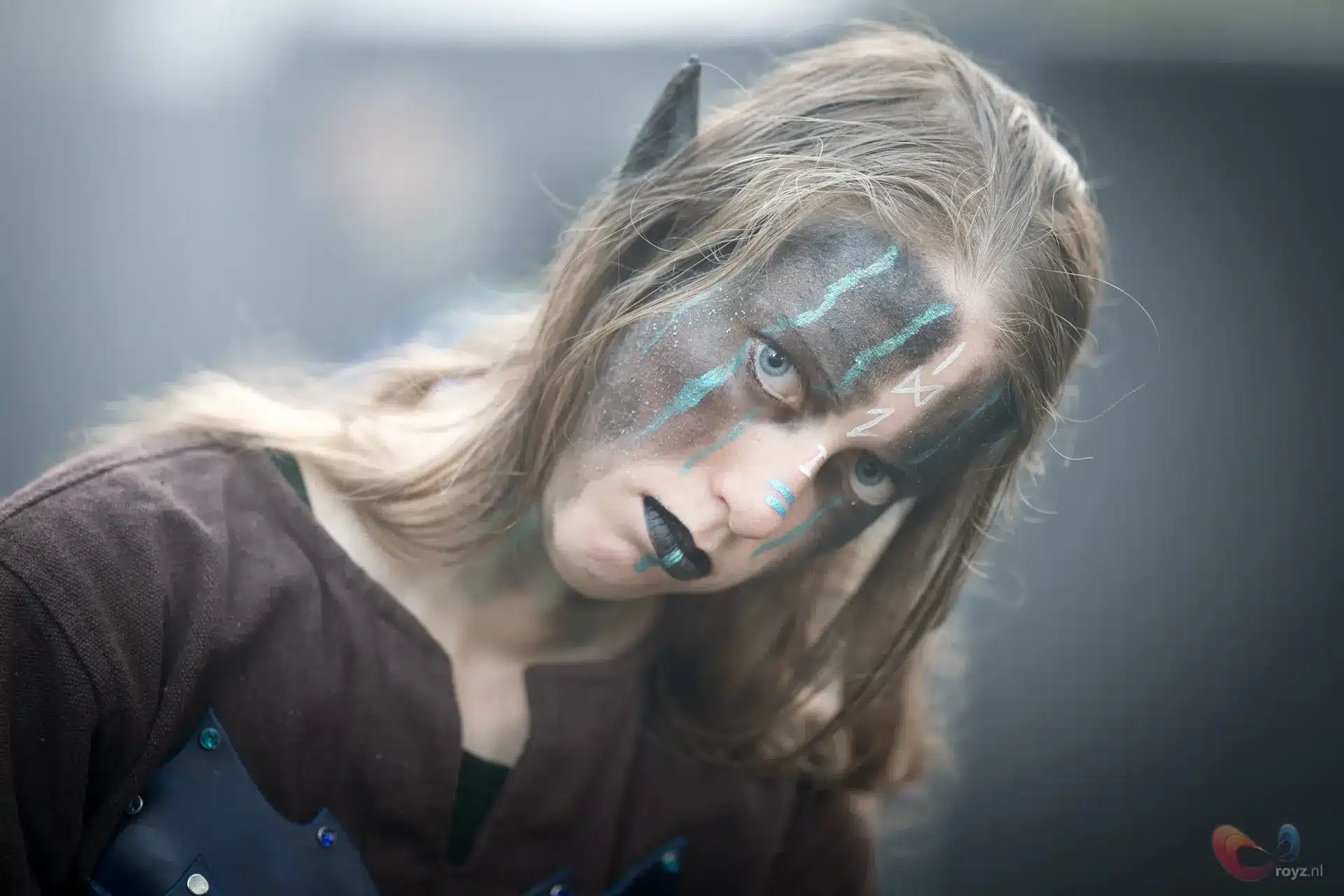 Fantasy krijger portret met hoorn, turkoois gezichtsmarkeringen en middeleeuws blauw borststuk.