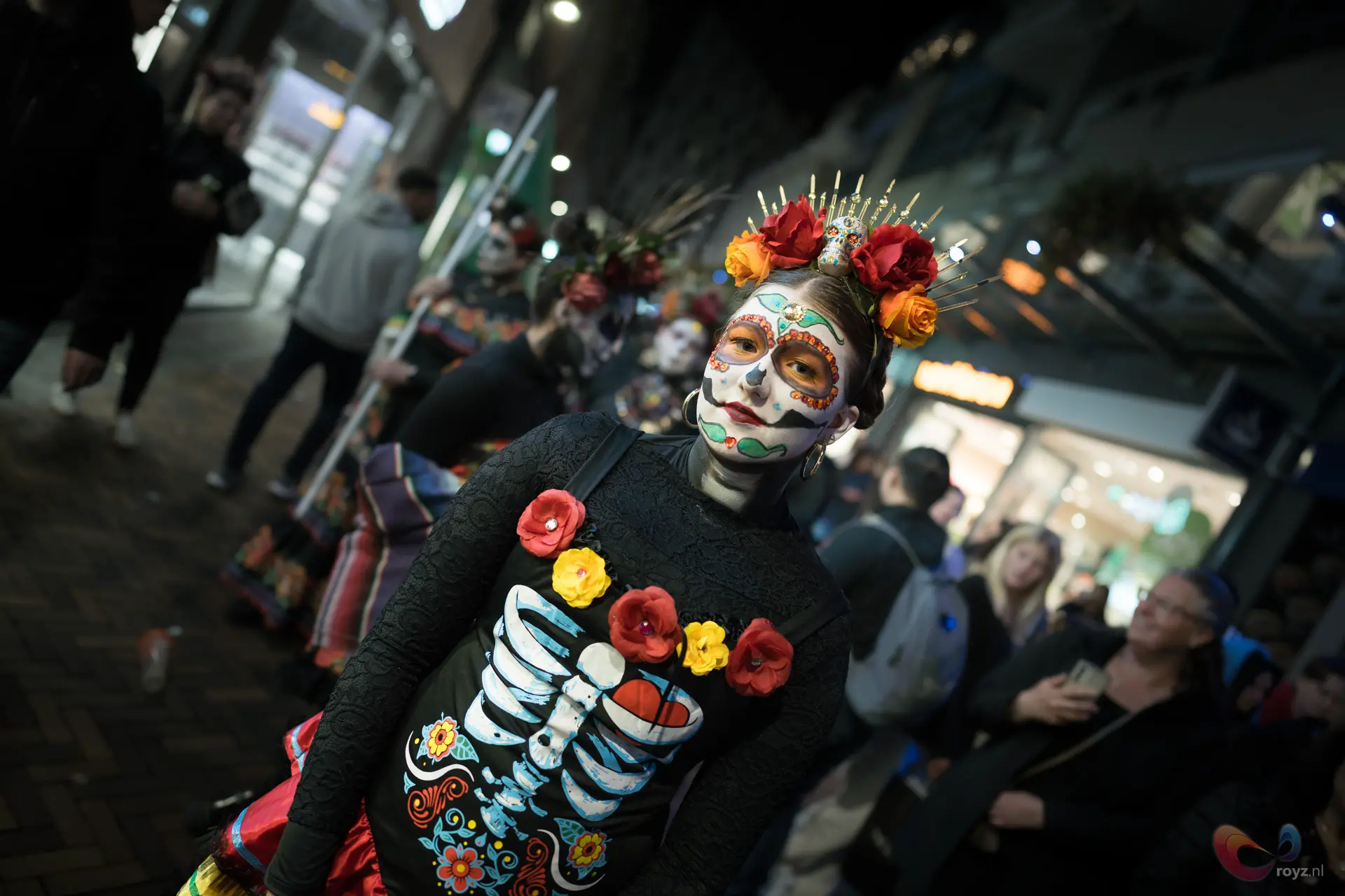 Dia de los Muertos suikergezicht tijdens Zoetermeer nachtparade met rozenkroon en ribcage-afdruk.
