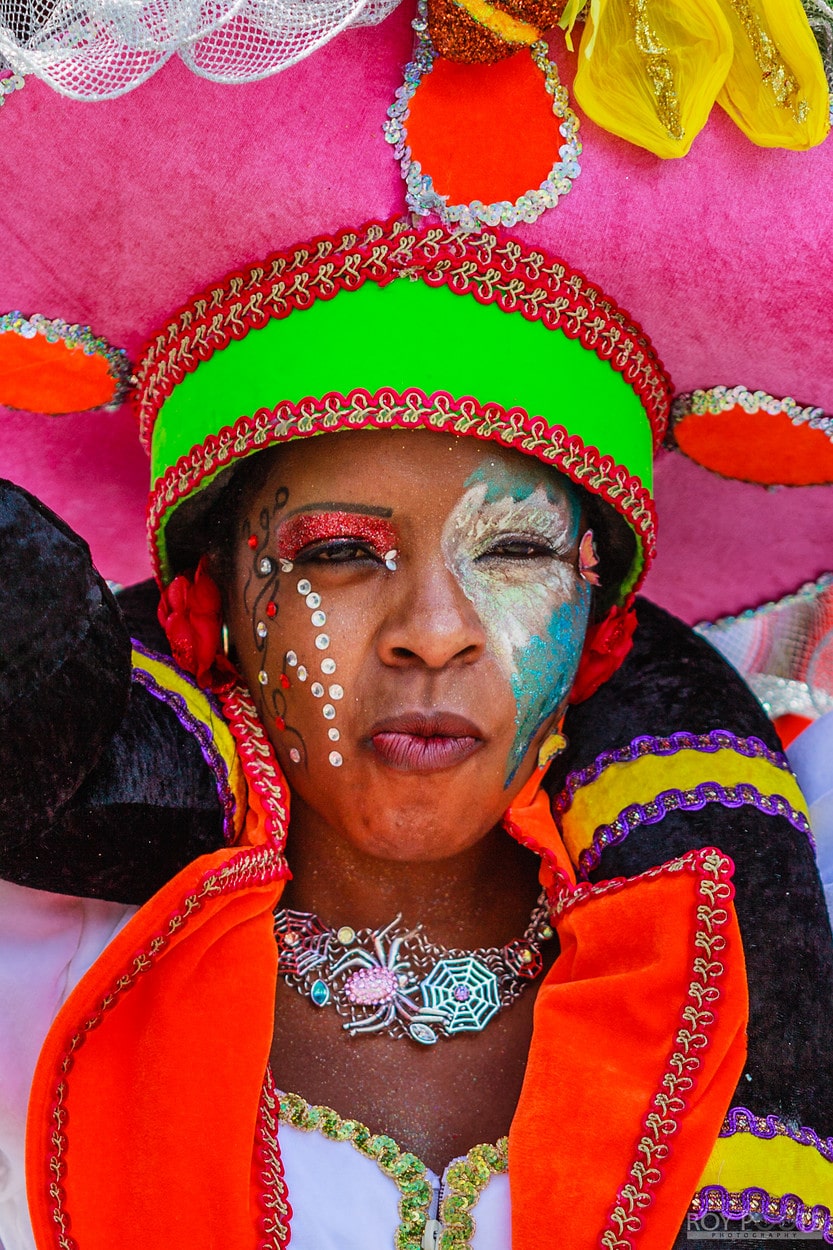 Korte close-up van carnavalspersoon met neon groene hoofdband en dramatische make-up.