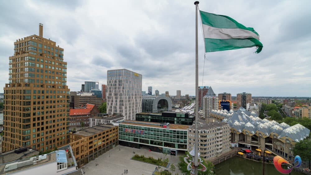 Nigeriaanse vlag wappert boven dakterras met moderne skyline en kanaal.