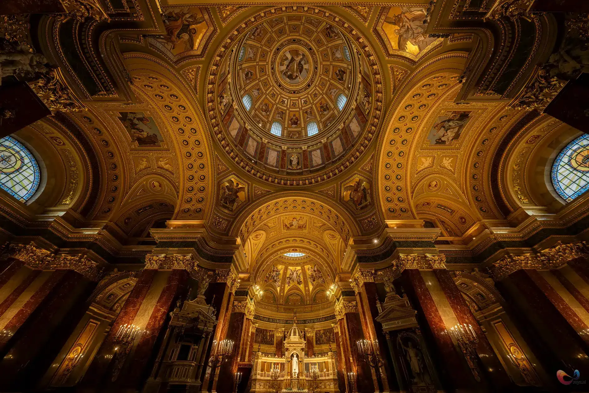 Matthiaskerk Budapest: gouden koepel, marmeren kolommen, altaar en kaarslicht.
