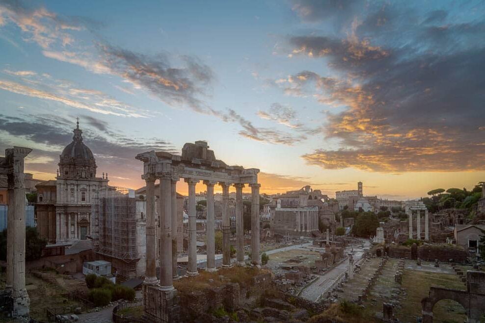 Romeinse ruïnes bij zonsondergang met kolommen, koepel en steigers in Rome
