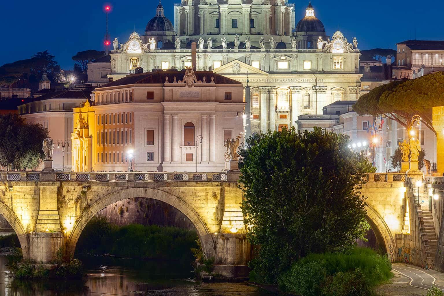 Rome bij nacht: Sint-Pietersbasiliek aan de Tiber en stenen brug.