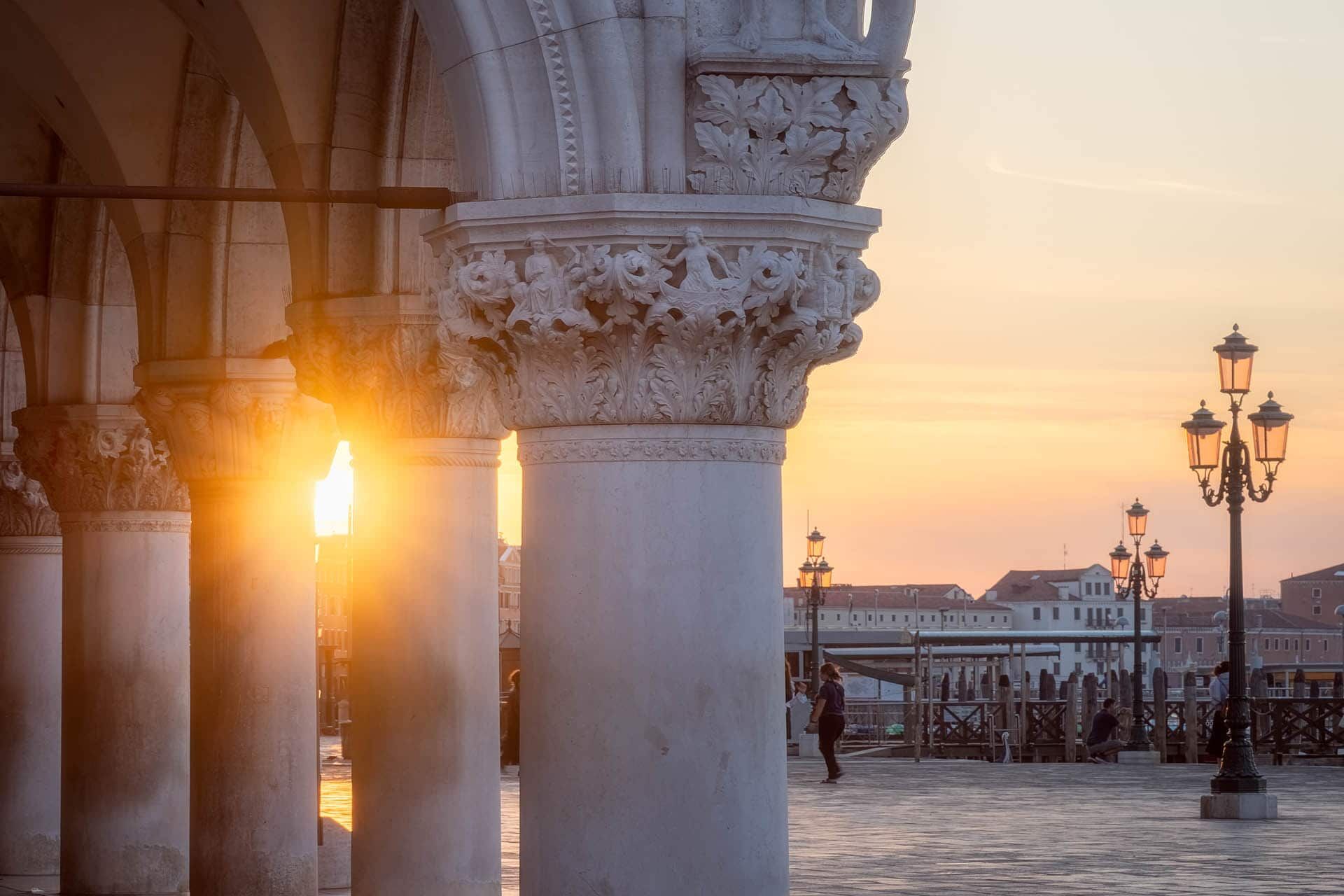 Venetië: arcade langs haven bij zonsondergang, kolommen met acanthus-kapitelen.