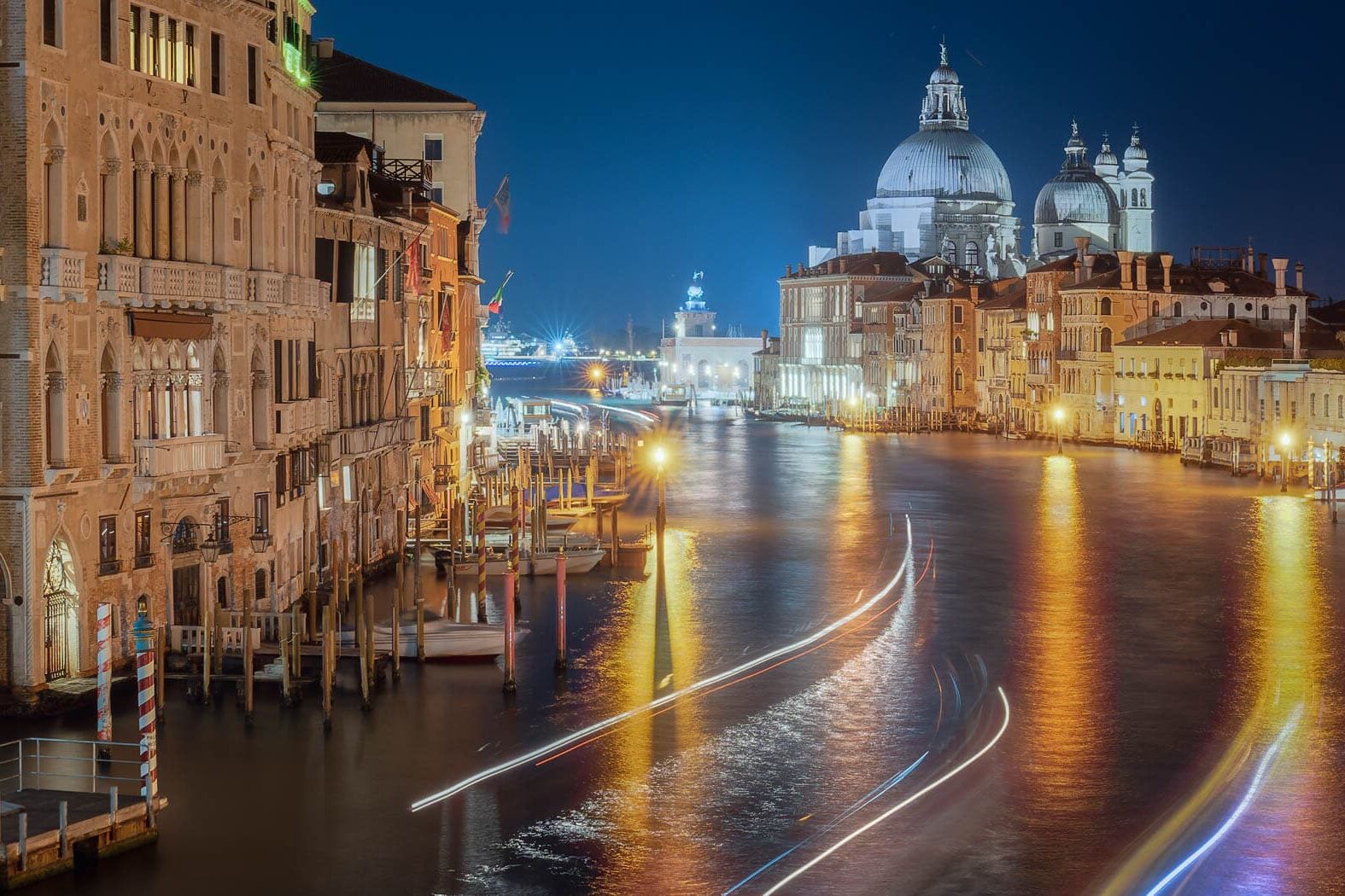 Nachtzicht op Venetië langs het Grand Canal met amberkleurige lichten en Santa Maria della Salute.
