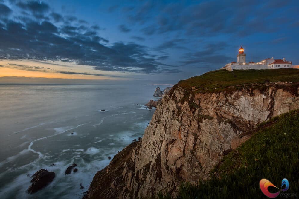 Vuurtoren op Cabo da Roca aan ruige kustkliffen bij zonsondergang.